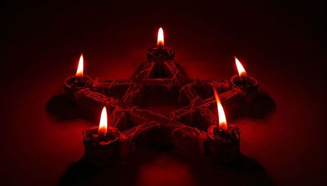 Pentagram candle display in dark ritual setting