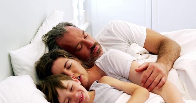 Family sleeping in bedroom at home