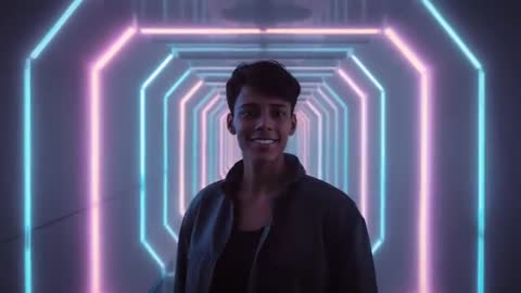 Young man smiling while walking through neon LED tunnel with cyan and pink hex frames