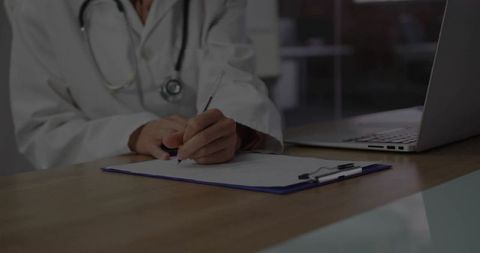 Doctor Writing on Clipboard in Modern Clinic