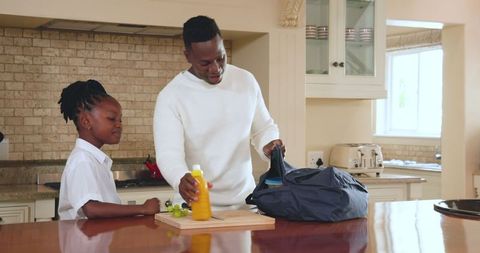 Father Packing Lunch with Daughter in Modern Kitchen