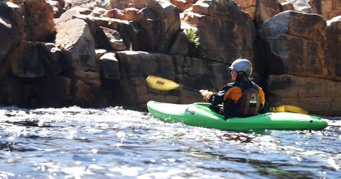 Kayaker navigating rapids in breathtaking riverscape