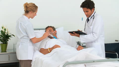 Doctors Monitoring Unconscious Patient at Hospital Bedside