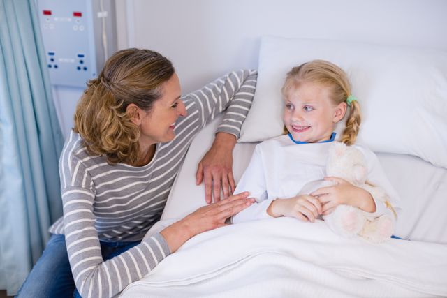 Mother talking to daughter in hospital bed - Download Free Stock Photos Pikwizard.com