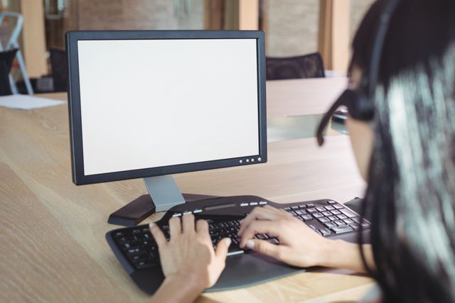 Cropped image of businesswoman working on computer at desk in call center