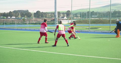 Teammates engaging in field hockey match competitive play