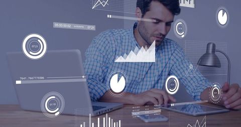 Analyzing data on tablet with laptop and augmented HUD dashboards for business insights