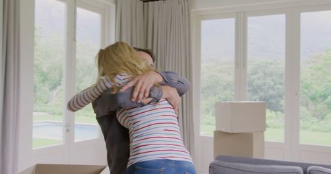 Joyful couple hugging after moving into new home
