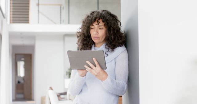 Woman with Curly Hair Using a Tablet in Modern Home Interior - Download Free Stock Images Pikwizard.com