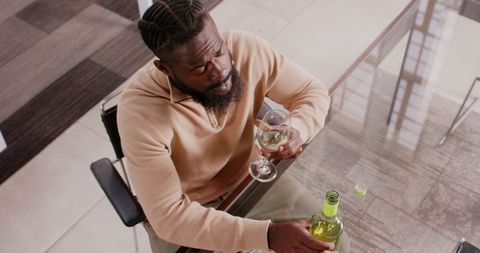 Professional Man Contemplatively Pouring White Wine in Office