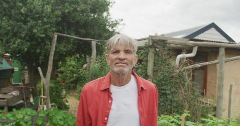 Senior Man Enjoying Gardening in Lush Backyard