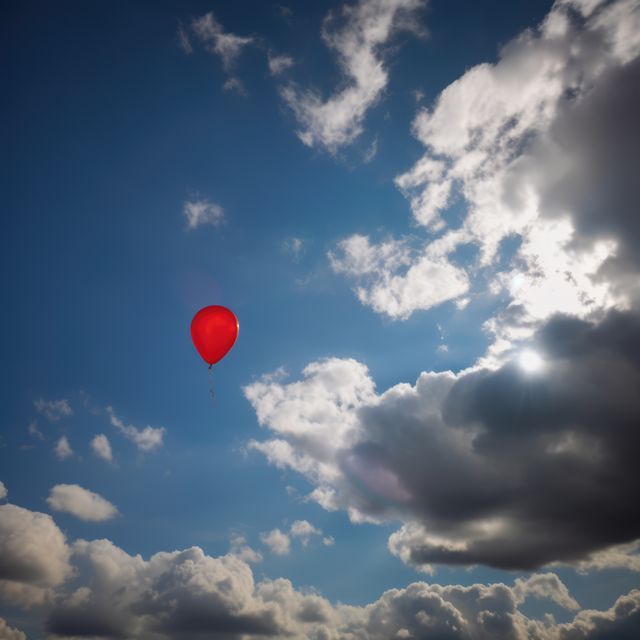Red balloon floating against a backdrop of blue sky and dramatic clouds, symbolizing freedom and whimsy. Ideal for themes of celebration, childhood, adventure, and escape. Perfect for use in advertisements, inspirational posters, and background images for blogs and websites.