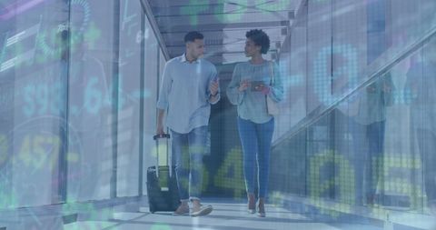 Business travelers discussing work walking through airport