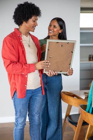 Couple reviewing rustic picture frame in cozy home