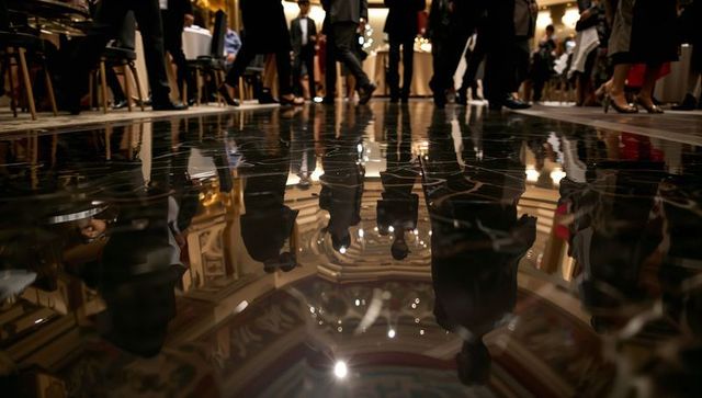 Reflecting silhouettes walking on polished ballroom floor at luxury gala