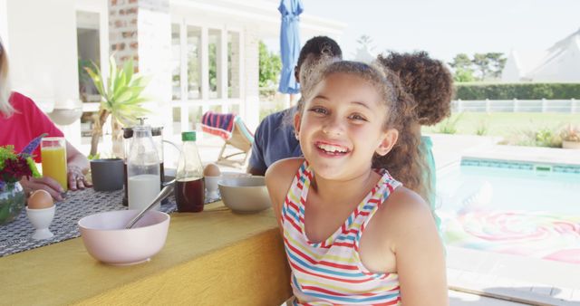 Image of biracial girl with diverse family spending time together and having dinner outside. Family life, spending time together with family.