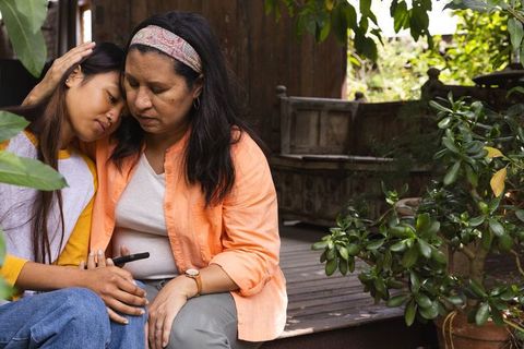 Mother Comforting Daughter in Tranquil Backyard Setting