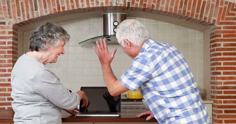 Senior Couple Video Chatting at Home in Kitchen Setting