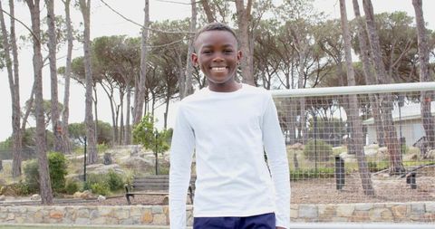 Joyful boy in nature bonding with soccer outdoors