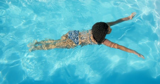 Young child swimming in pool with blue water on sunny day - Download Free Stock Images Pikwizard.com