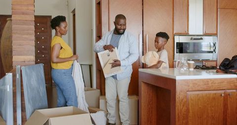 African American Family Unpacking Joyfully in Warm Wood Kitchen During Move