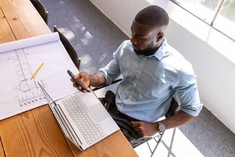 Architect Consulting Smartphone and Laptop Blueprint Drawing Office Desk