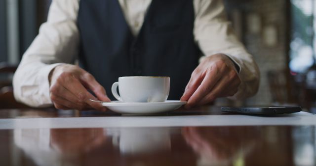 Man in vest holding coffee cup on saucer in cafe - Download Free Stock Images Pikwizard.com