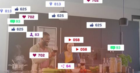Couple preparing dinner in modern kitchen while receiving social media likes and comments