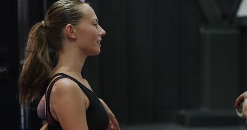 Female athlete preparing with gym trainer for intense workout