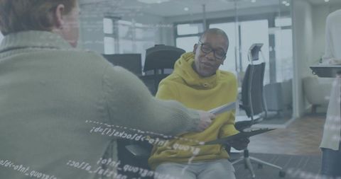Collaborating on code and documents with glass overlay in modern office, man receiving paper