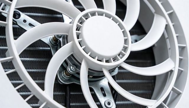Axial condenser fan cooling coil close-up with blades motor hub and mounting hardware