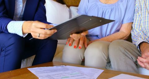 Real estate agent discussing documents with seniors at home