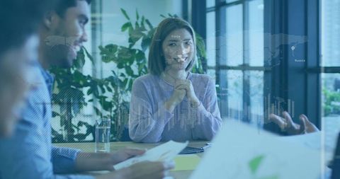 Business Team Collaborating in Modern Office with Digital World Map Overlay
