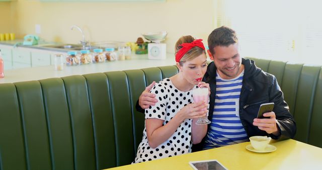 Young couple enjoying milkshake at retro diner - Download Free Stock Images Pikwizard.com