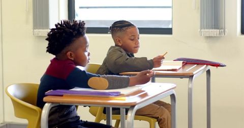 Two boys concentrating on classroom assignments
