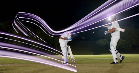 Cricket players sprinting across night pitch with dynamic purple light trails