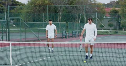 Two tennis players at net preparing shot with pink-grip racket on outdoor court