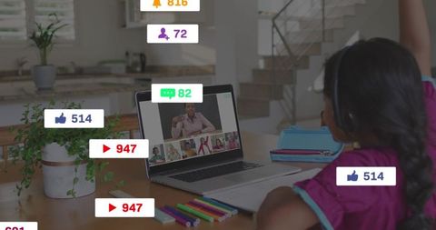 Young student reaching laptop during remote class wearing headset and colorful braids