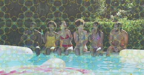 Friends relaxing on pool edge sipping drinks laughing during sunny summer pool party