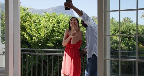 Unique Engagement Proposal on Sunlit Balcony with Mountain View