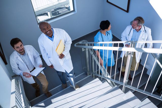 Portrait of doctors interacting with each other while climbing stairs at hospital
