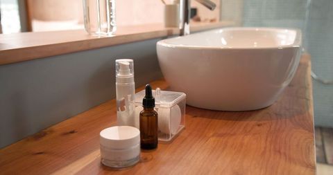 Modern Skincare Bottles on Natural Wood Bathroom Counter