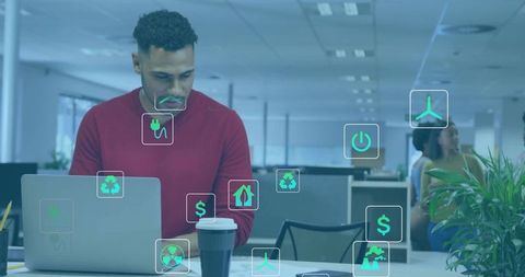 Professional working on laptop in open office with green sustainability icons overlay