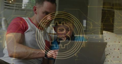 Father teaching son cryptocurrency basics on laptop with bitcoin overlay at home