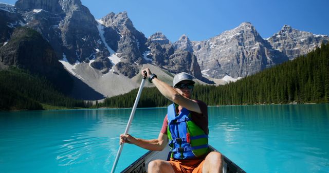 Man Canoeing in Pristine Mountain Lake - Download Free Stock Photos Pikwizard.com