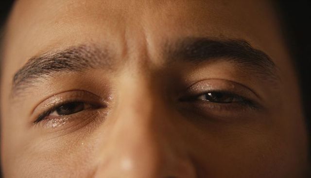 Male gaze displaying furrowed brows and warm skin texture closeup for dramatic portrait
