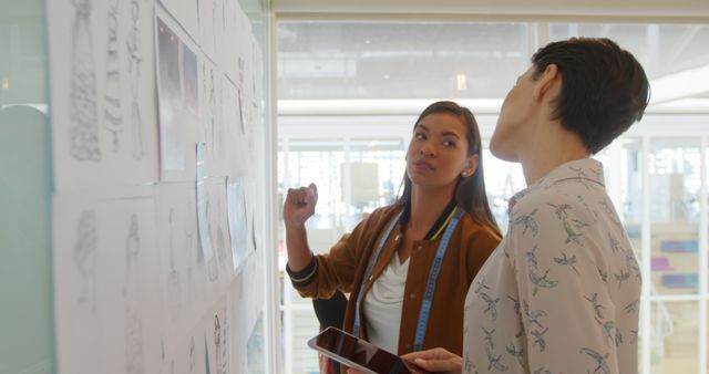 Female Designers Discussing Fashion Designs on Wall - Download Free Stock Images Pikwizard.com