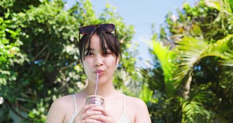 Woman enjoying cold beverage in lush garden setting