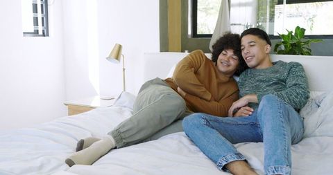 Cozy Male Partners Relaxing in Sunlit Bedroom