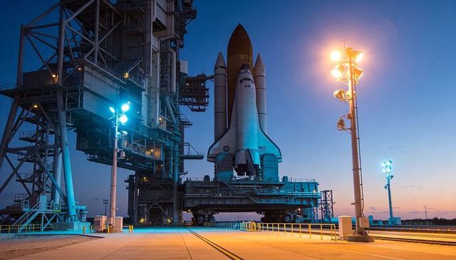 Space Shuttle Standing on Crawler at Launch Pad Twilight with Floodlights and Gantry